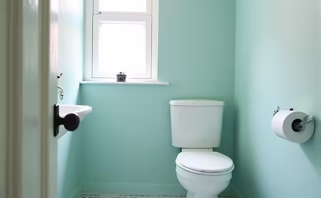 A small bathroom freshly painted in a light, soothing color, featuring waterproof paint with a glossy finish. The picture emphasizes the bright and spacious appearance brought by the new paint